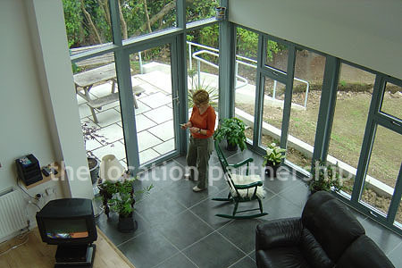 Double height sitting room/ conservatory with full length windows and overhead skylight.