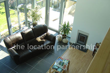 Double height sitting room/ conservatory with full length windows and overhead skylight.