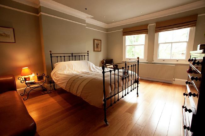 A large Victorian house with open plan ground floor and large white modern Kitchen/ Dining area with floor to ceiling windows and double length sitting room.