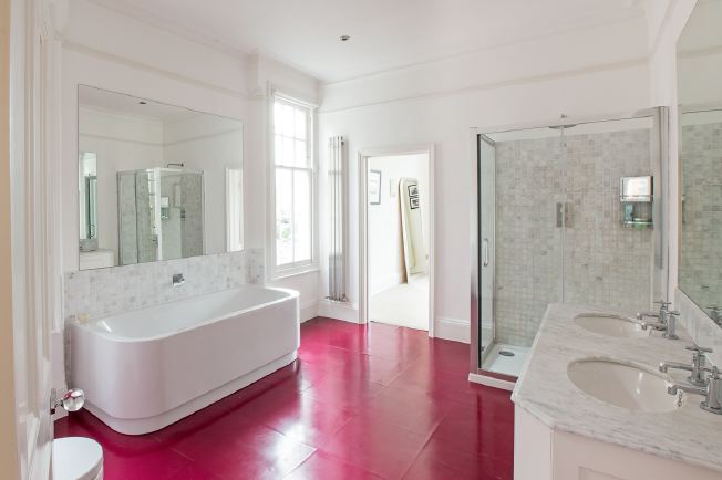 Spacious, modern bathroom with bath and shower units.