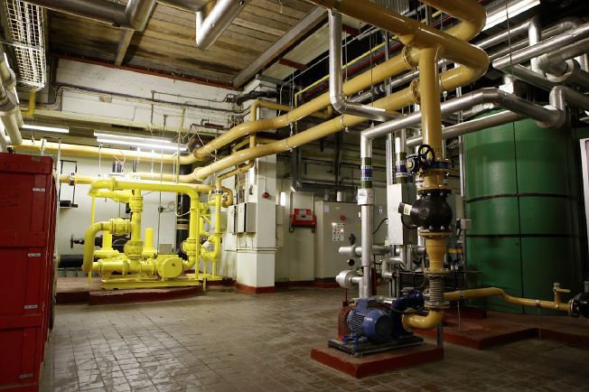 Subterranean network of corridors, tunnels and rooms with industrial pipes and features.