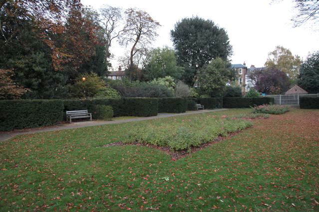 Beautiful historic house garden with an old stone bridge, walled gardens, manicured hedges, a circular pond and an ornate fountain