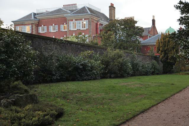 Beautiful historic house garden with an old stone bridge, walled gardens, manicured hedges, a circular pond and an ornate fountain