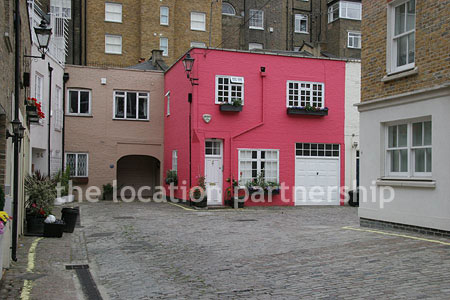 Cobbled mews with some loudly painted houses