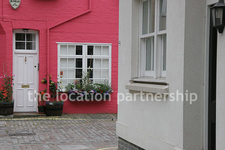 Cobbled mews with some loudly painted houses