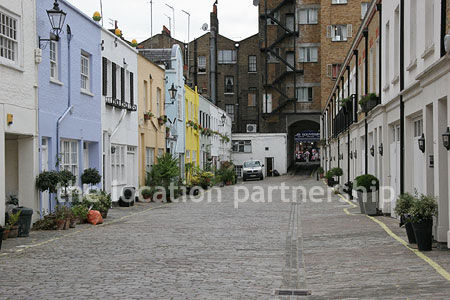 Cobbled mews with some loudly painted houses