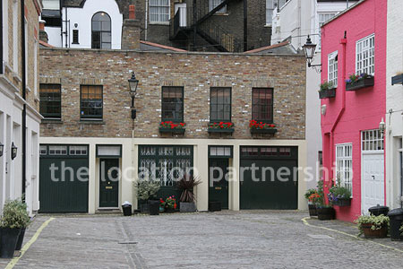 Cobbled mews with some loudly painted houses