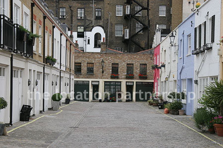 Cobbled mews with some loudly painted houses