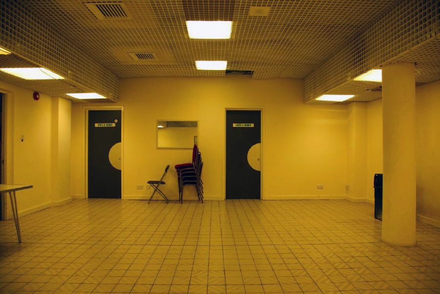 White tiled waiting area with grid pattern ceiling outside changing rooms