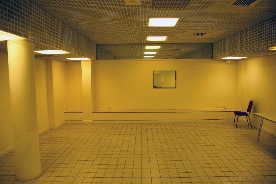 White tiled waiting area with grid pattern ceiling outside changing rooms