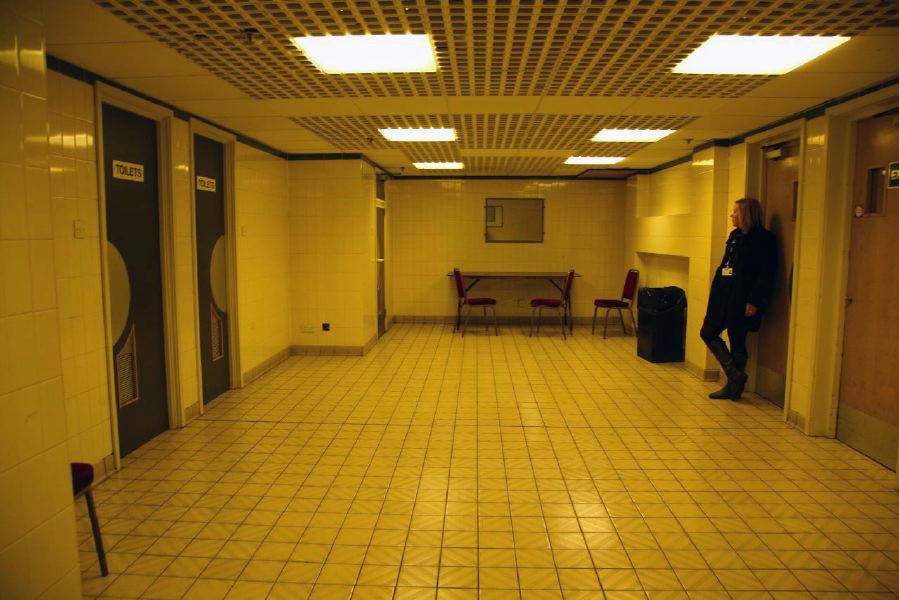 White tiled waiting area with grid pattern ceiling outside changing rooms