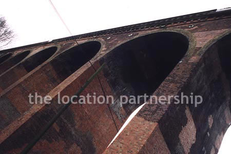 Viaduct over quiet country lane and river.``Just outside M25